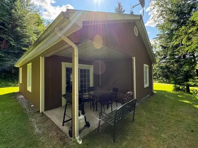 a small house with a porch and a table at Havre De Paix in Piopolis