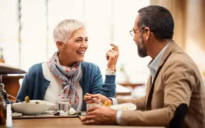a man and a woman sitting at a table eating food at Holiday Inn Hotel & Suites - Montreal Centre-ville Ouest by IHG in Montréal
