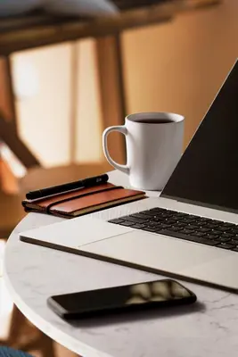 a laptop computer and a cup of coffee on a table at Holiday Inn Hotel & Suites - Montreal Centre-ville Ouest by IHG in Montréal