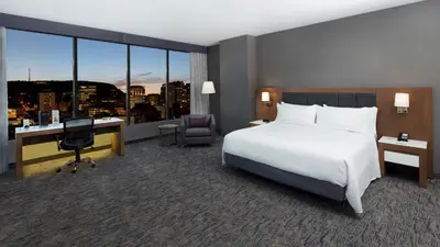 a hotel room with a bed and a desk with a computer at Holiday Inn Hotel & Suites - Montreal Centre-ville Ouest by IHG in Montréal