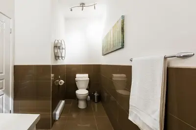 a bathroom with a toilet and a shower and a sink at MTLVacationRentals -The Chic Laurier in Montréal