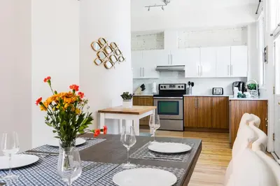 a kitchen with a table with plates and flowers on it at MTLVacationRentals -The Chic Laurier in Montréal