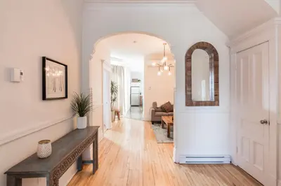 a hallway with a table and a living room at MTLVacationRentals -The Chic Laurier in Montréal