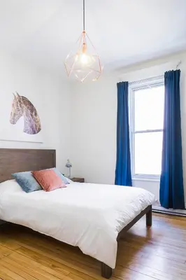 a bedroom with a large bed with blue curtains at MTLVacationRentals -The Chic Laurier in Montréal
