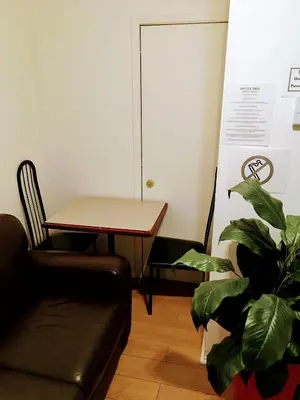a living room with a couch and a table and a plant at Hotel Mini Inc in Montréal