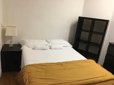 a bedroom with a large bed with white sheets at Hotel Mini Inc in Montréal
