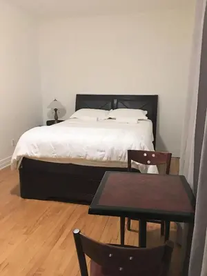 a bedroom with a bed and a table and chairs at Hotel Mini Inc in Montréal