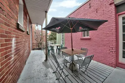 a table and chairs with an umbrella on a patio at Hotel Mini Inc in Montréal