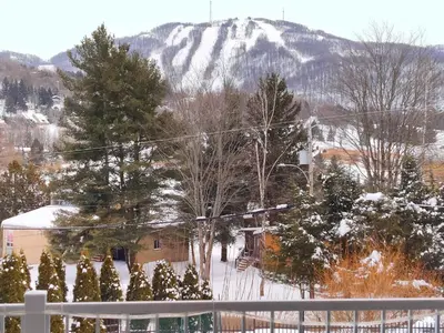 a view of a snow covered mountain from a balcony at Le 204 Champlain Bromont in Bromont