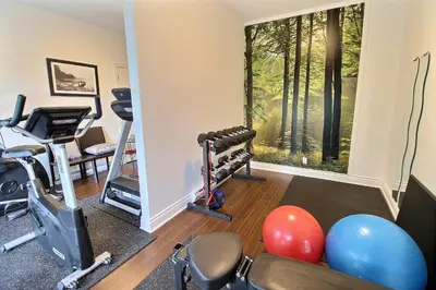 a room with a gym with exercise equipment and a window at Le 204 Champlain Bromont in Bromont