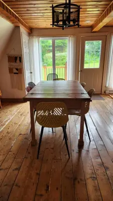a large wooden table in a room with chairs at Chalet du barrage in East Broughton Station