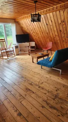 a living room with a blue couch and a piano at Chalet du barrage in East Broughton Station