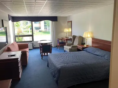 a hotel room with a bed and a living room at Hôtel Motel Le Voyageur in Saint-Georges