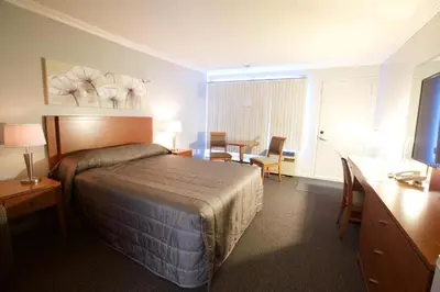 a hotel room with a bed and a table and chairs at Hôtel Motel Le Voyageur in Saint-Georges