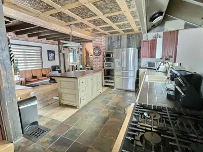 a kitchen with a refrigerator and a stove at Maison du Mont-Mégantic spa à l'année in Lac-Mégantic