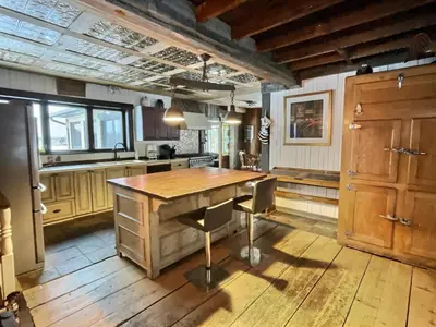 a kitchen with a wooden table and a counter at Maison du Mont-Mégantic spa à l'année in Lac-Mégantic
