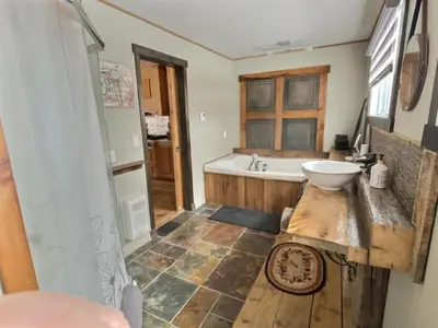 a bathroom with a tub and a sink at Maison du lac in Lac-Mégantic