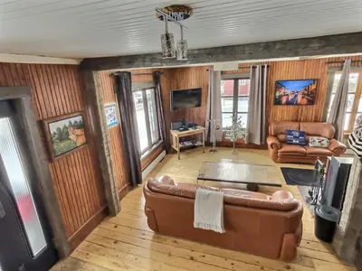 a living room with a couch and a tv at Maison du lac in Lac-Mégantic