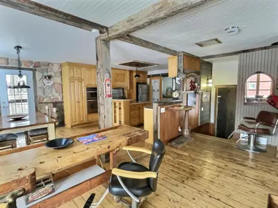 a kitchen with wooden floors and a wooden table and chairs at Maison du lac in Lac-Mégantic