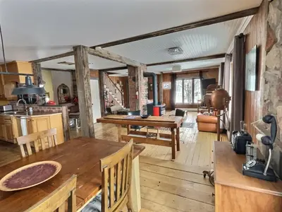 a kitchen and living room with a wooden table at Maison du lac in Lac-Mégantic