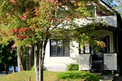 a white house with trees in front of it at Maison du lac in Lac-Mégantic
