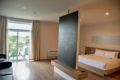 a bedroom with a bed and a large window at Hotel du Lac Champlain in Venise-en-Québec