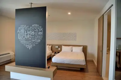 a bedroom with a bed and a wall with writing on it at Hotel du Lac Champlain in Venise-en-Québec