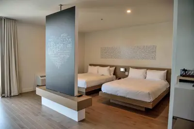 a bedroom with two beds and a wall at Hotel du Lac Champlain in Venise-en-Québec