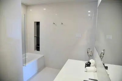a white bathroom with a tub and a sink at Hotel du Lac Champlain in Venise-en-Québec