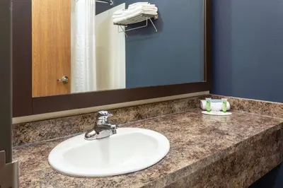 a bathroom counter with a sink and a mirror at Super 8 by Wyndham Lachenaie/Terrebonne in Terrebonne