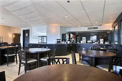 a restaurant with tables and chairs and a bar at Super 8 by Wyndham Lachenaie/Terrebonne in Terrebonne