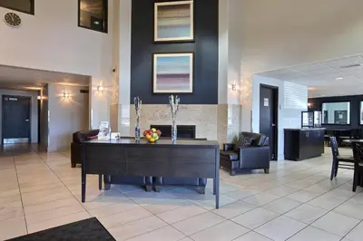 a living room with a table and a fireplace at Super 8 by Wyndham Lachenaie/Terrebonne in Terrebonne
