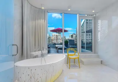 a bathroom with a tub and a table with an umbrella at Le Mount Stephen in Montréal