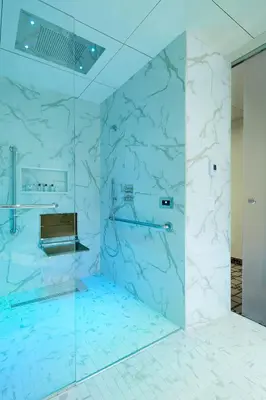 a bathroom with a shower with blue marble walls at Le Mount Stephen in Montréal