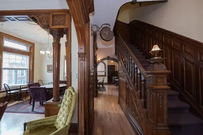 a hallway with a wooden staircase in a house at Manoir Sherbrooke in Montréal
