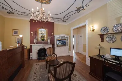 a living room with a fireplace and a chandelier at Manoir Sherbrooke in Montréal