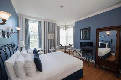 a bedroom with blue walls and a bed and a mirror at Manoir Sherbrooke in Montréal