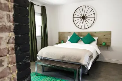 a bedroom with a bed and a clock on the wall at L'Hotel Particulier Griffintown in Montréal