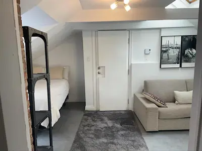 a bedroom with a bunk bed and a couch at L'Hotel Particulier Griffintown in Montréal