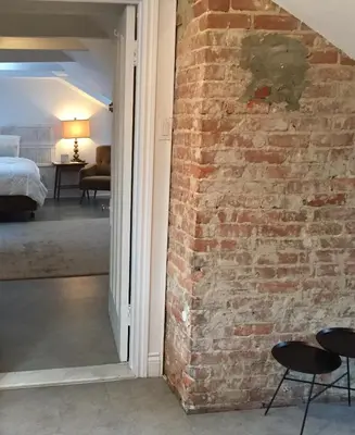 a brick wall with two chairs and a bedroom at L'Hotel Particulier Griffintown in Montréal