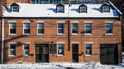 a red brick building with snow on the roof at L'Hotel Particulier Griffintown in Montréal