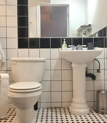 a bathroom with a toilet and a sink at L'Hotel Particulier Griffintown in Montréal