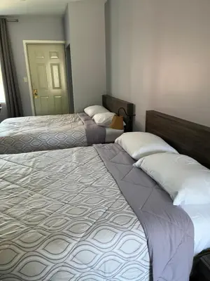 two beds sitting in a room with a door at Motel la Siesta de Gascon in Terrebonne