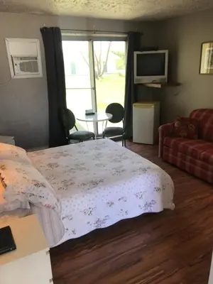 a bedroom with a bed and a couch and a window at Motel la Siesta de Gascon in Terrebonne