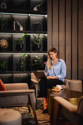 a woman sitting in a chair with a laptop at Montreal Marriott Chateau Champlain in Montréal