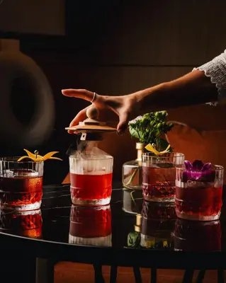 a person pointing at a table with four drinks at Montreal Marriott Chateau Champlain in Montréal