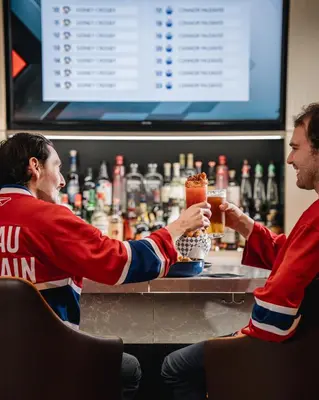 two men sitting at a bar with drinks at Montreal Marriott Chateau Champlain in Montréal