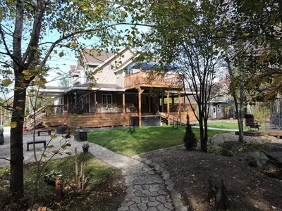 a large house with a porch and a deck at Gite Passion et Tendresse B&B in Shefford