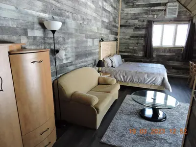 a bedroom with a bed and a chair and a table at Gite Passion et Tendresse B&B in Shefford