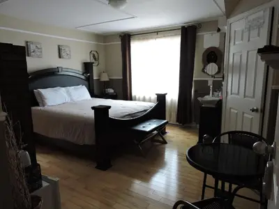 a bedroom with a bed and a table and a window at Gite Passion et Tendresse B&B in Shefford